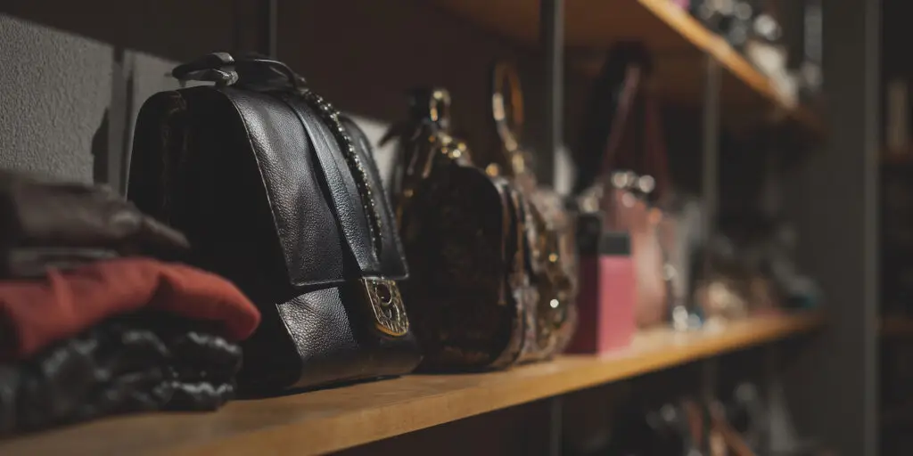 bags and folded clothing on shelving in a charity shop