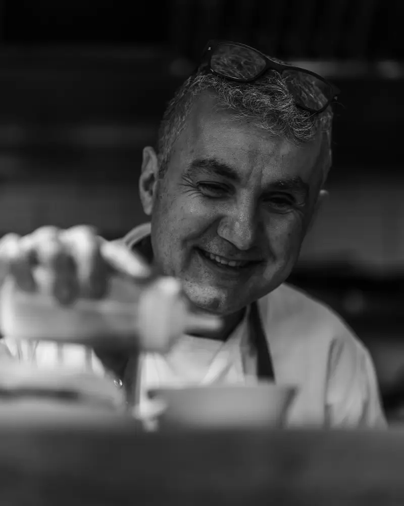 john gionleka finishing a dish with little olive oil evoo